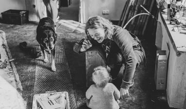 Moment de complicité entre une femme et un bébé pendant qu'un chien regarde l'objectif, Elmes Zohra