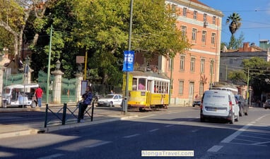 Yellow Lisbon tram 28 in front of the beautiful Jardim da Estrela