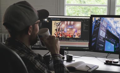 Vincent Dumont regarde ses écrans de montage en prenant un thé
