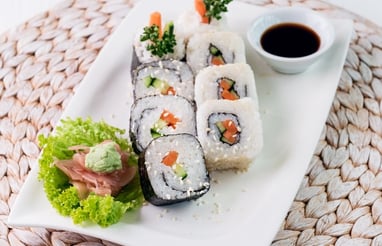 a plate with veggie sushi and sauce