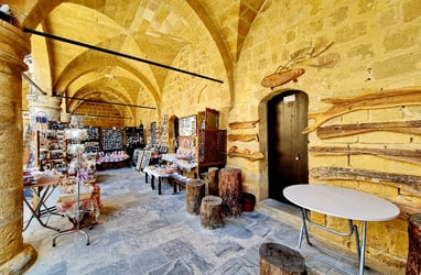 a store in Ledra North Cyprus with a table and chairs in front of a stone wall