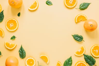 Yellow background with whole, cut, and sliced lemons and leaves