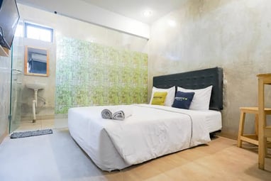 flazale reddoorz flash sale promo a bedroom with a bed and a television