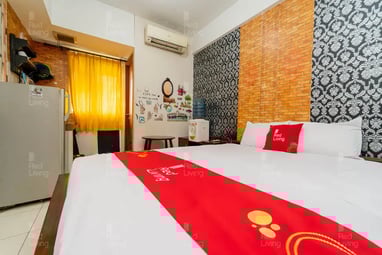 flazale reddoorz flash sale promo a bed with a red and white bedding and a refrigerator