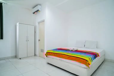 flazale reddoorz flash sale promo a bed with a colorful blanket and a white bed