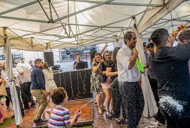 niño arrojando espuma loca a los invitados que bailan