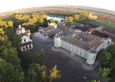 a large building with a lot of trees and a river