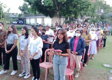 a group of people standing in a line of chairs