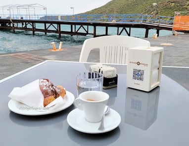 a chocolate croissant  & ☕ are served on a table overlooking the bay on Vulcano Island for a sweet treat with a  great view