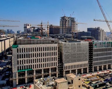 a city skyline view of a city with a lot of construction cranes