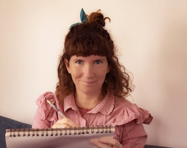 Photographie portrait d'Oriane Marie tenant un carnet et un crayon.