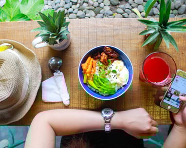 woman holding iphone while eating
