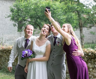 Photo prise sur le vif alors que les témoins et les mariés prennent un selfie