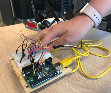 A person holding an Arduino for an interactive prototype.