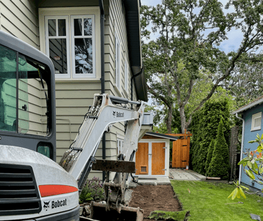 a construction worker is working on a house with bobcat excavator