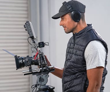 a man in a black vest and a camera with rode wireless pro