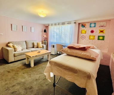 healing room with table, couch and massage table in pink