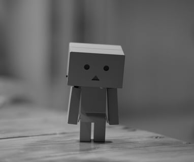 a small paper toy with a sad face