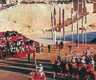 a group of people in a parade in front of a castle