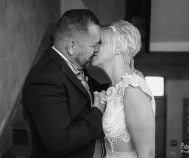 a bride and groom kissing on the stairs of a staircase