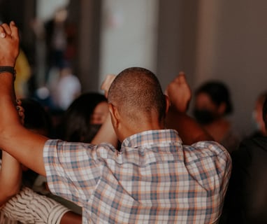 people holding hands up in the air in prayer and praise