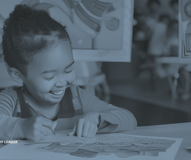 a young child is smiling and holding a coloring book