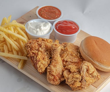 pollo frito crujiente con patatas y salsas mayonesa y ketchup