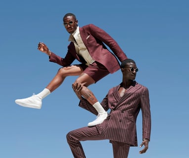 Deux hommes posant dans des costumes couleur terre, un en short : Mr Afropolitan x Suitsupply