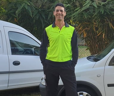 danny weller aqua clear window cleaning owner operator smiling in an outdoor setting, standing in front of work vehicles