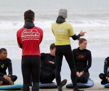 two surf coaches giving a safety brief while group listens.