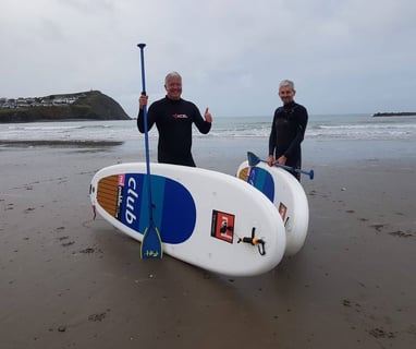 Derek 'The Weatherman' Brockway wituh paddle boards on Borth Beach.