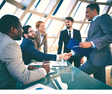 a man and woman shaking hands in a meeting room