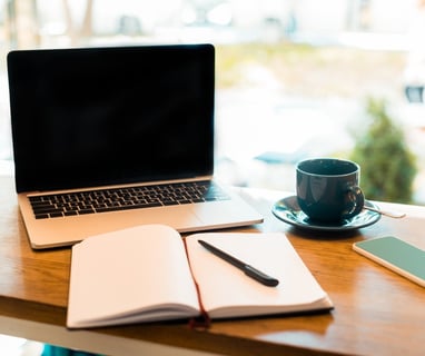 a laptop computer and a notebook on a table