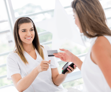 a woman is holding a credit card for a treatment at the salon