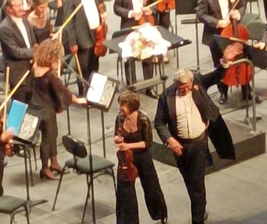 The conductor, accompanied by lead violinist .