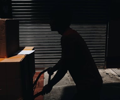 a man in a black shirt is moving boxes