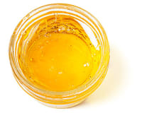 A little container of yellow apple jelly