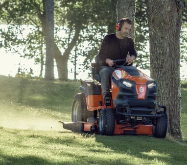 a man riding on a lawn mower with a lawn mower
