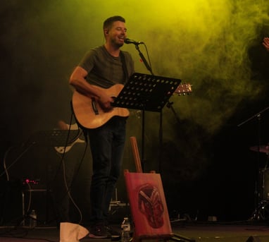 a man singing playing guitar and leading worship