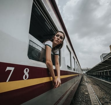 A solo female traveler looking out from a train window