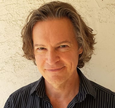 Headshot of Todd Long smiling with medium-length hair