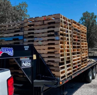 a truck with a load of used wood pallets on it