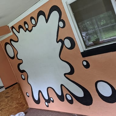 a room with a wall mural of a large splat