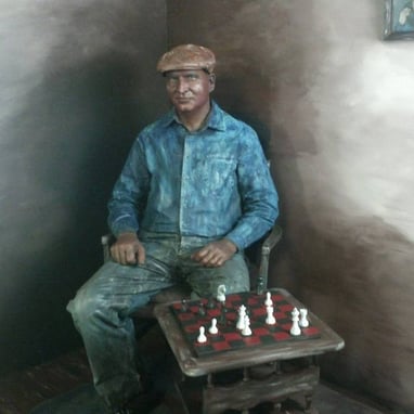 a statue of a man sitting in a chair