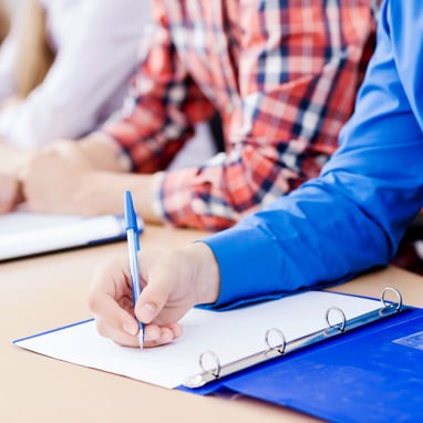 Student taking notes at a lecture.