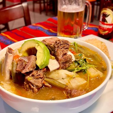 a bowl of soup with a beer and a beer