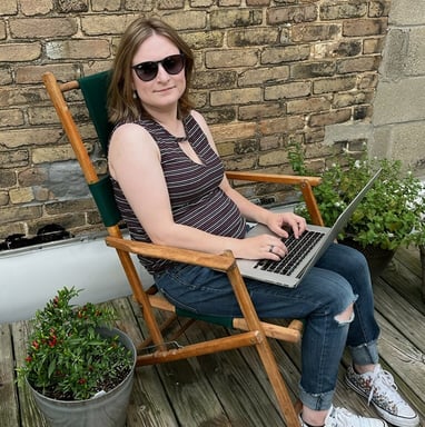 a woman sitting in a chair with a laptop