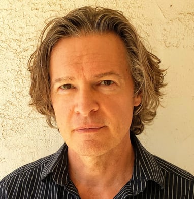 Todd Long with medium-length hair and serious expression