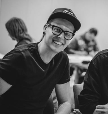 a man in a black shirt and glasses smiling