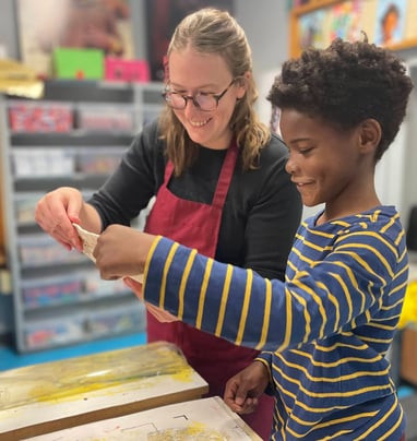 One of our teachers printing with a smiling Benton student.